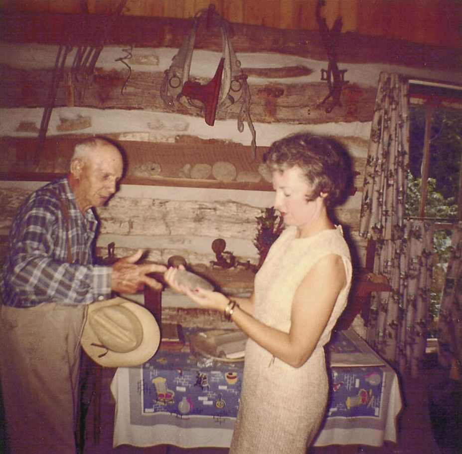 Henry Rogler with Mrs. James Folsom examining artifacts in the log cabin 