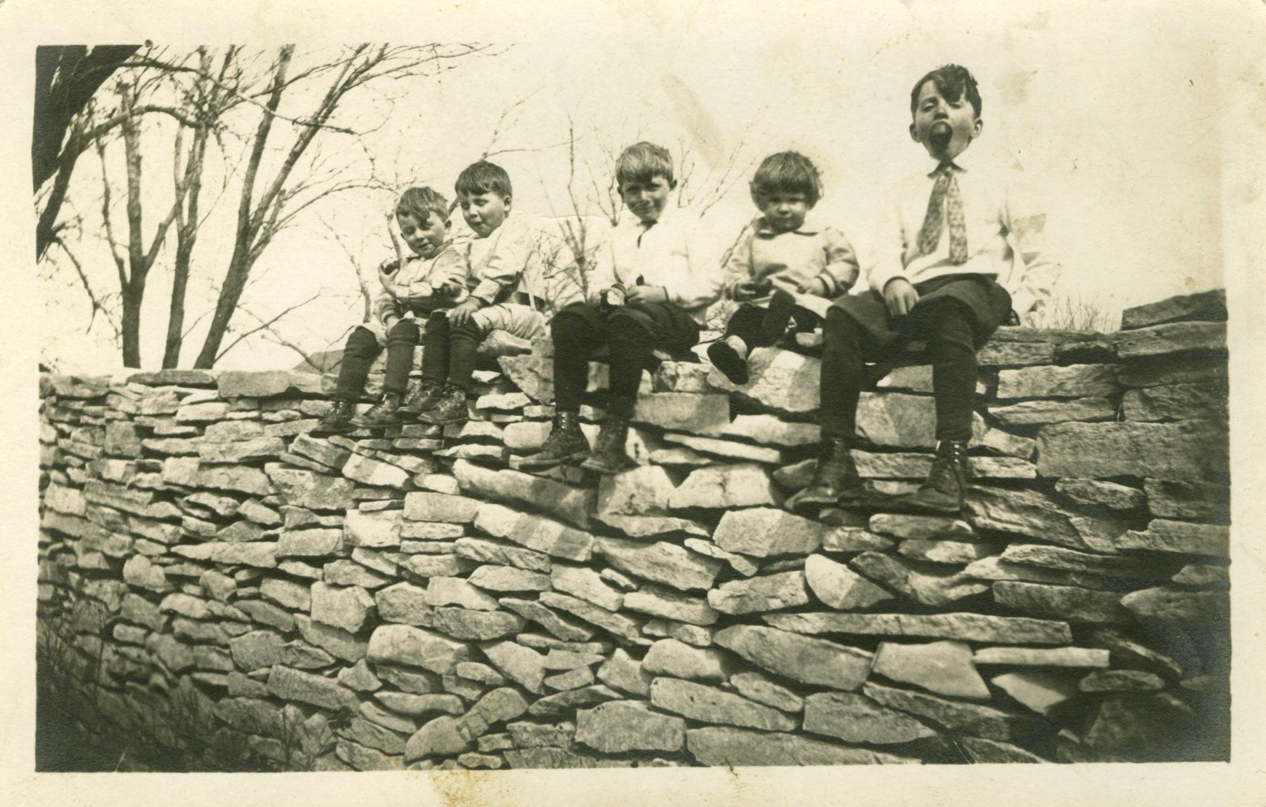 Children sitting on the stone fence